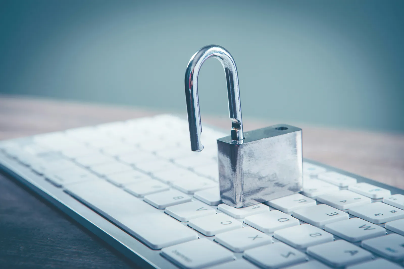 Open padlock resting on a white keyboard